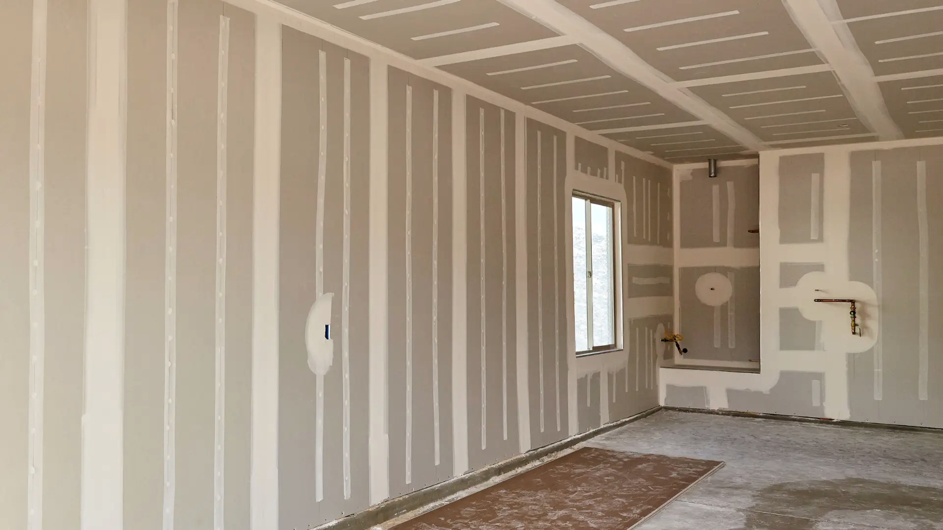 Parede de drywall com juntas tratadas, pronta para pintura